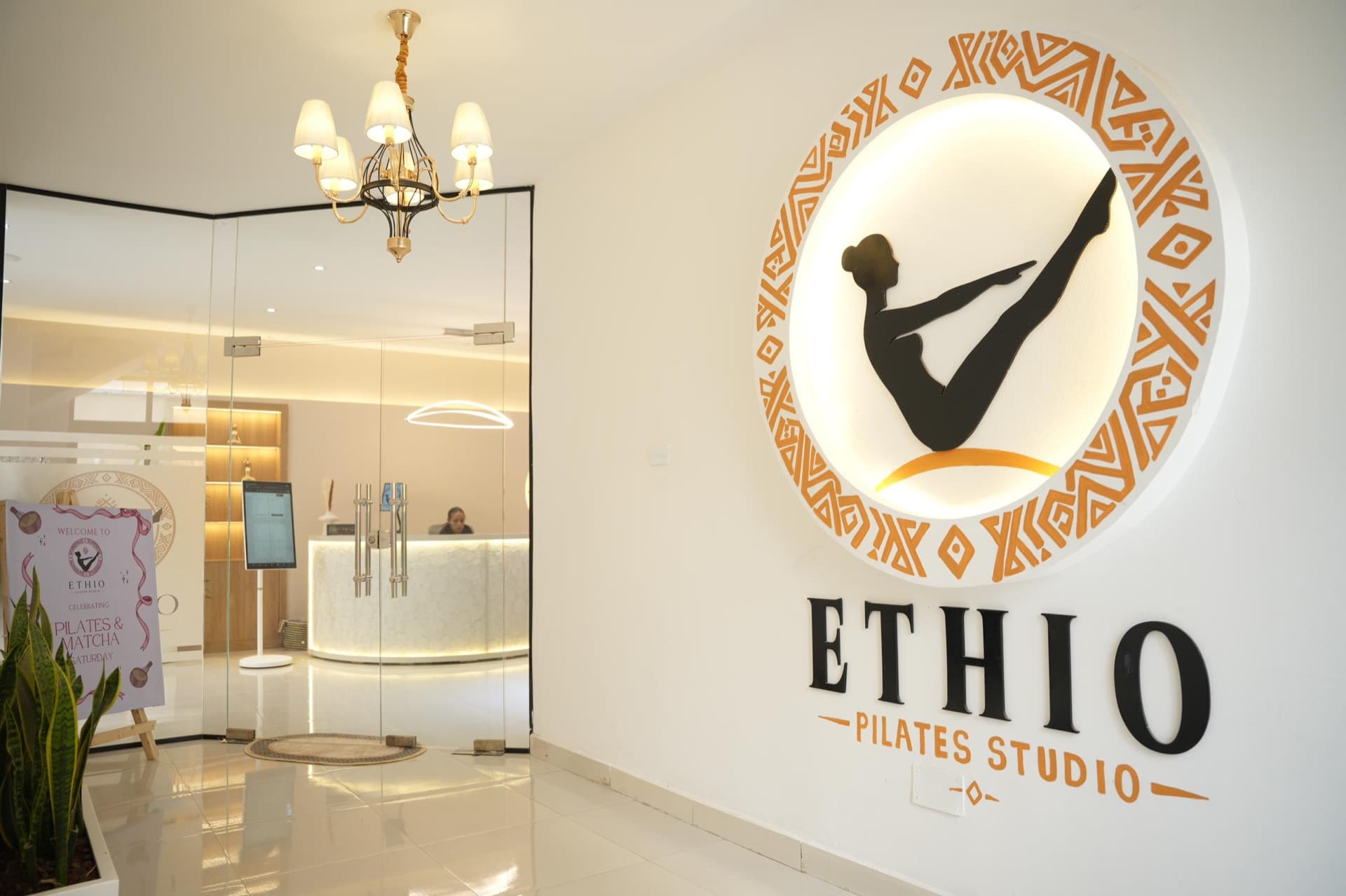 The Ethio Pilates Studio entrance, its round patterned logo glowing on the wall