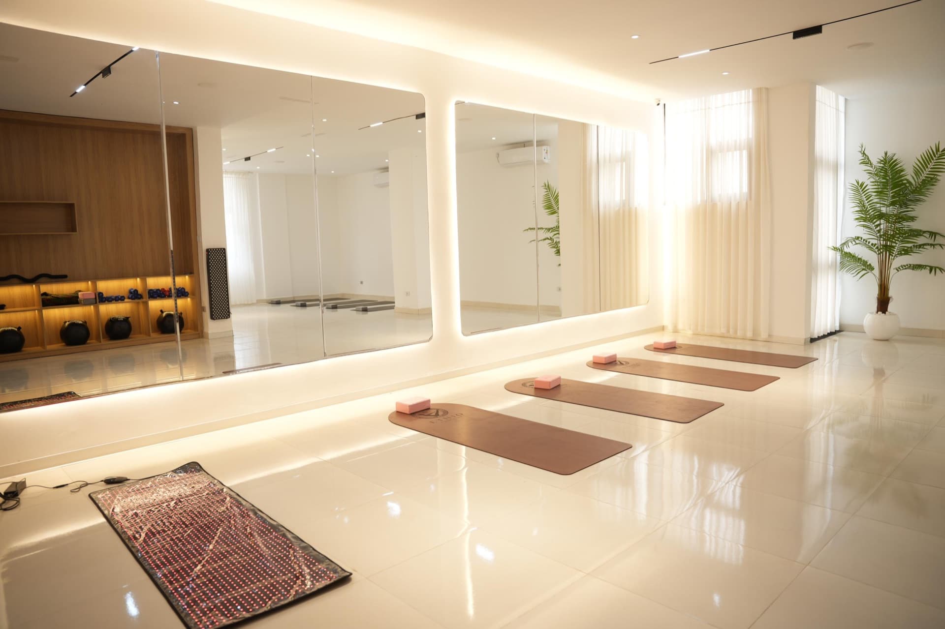 The bright mirrored mat studio with mats arranged in neat rows