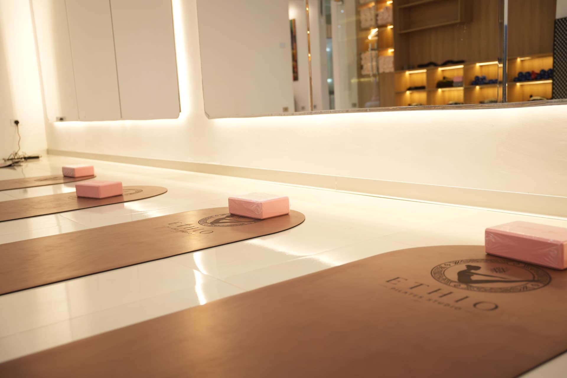 Studio mats and props waiting in soft light before a yoga class